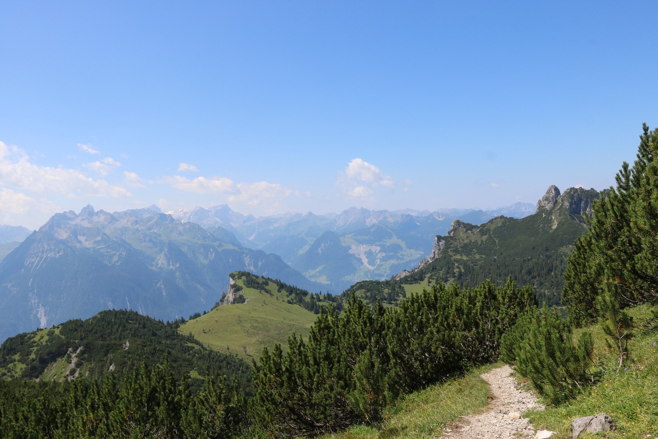 Schmaler Wanderweg mit weitem Blick auf die Berge