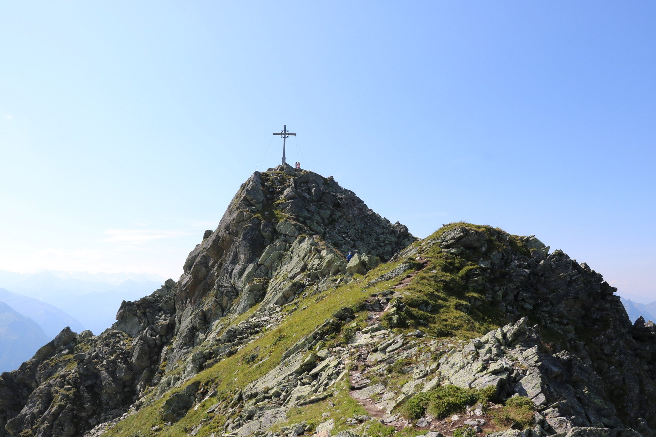 Gipfelkreuz auf einem felsigen Berggrat