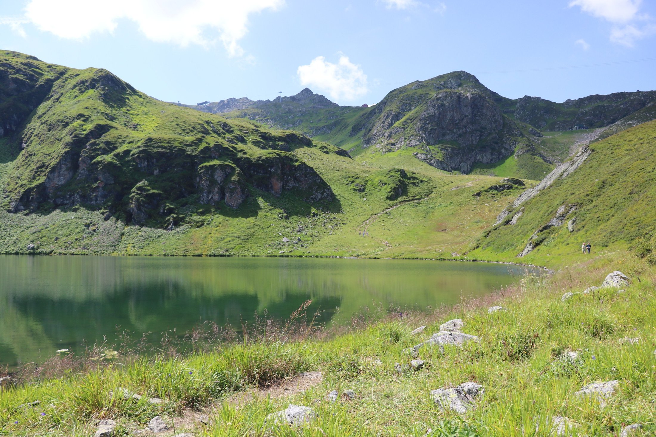 Grüner Bergsee inmitten der alpinen Landschaft