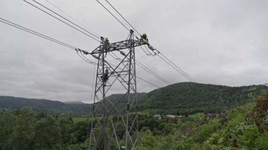 Bilde av noen Tensio-montører oppe i en høyspentmast