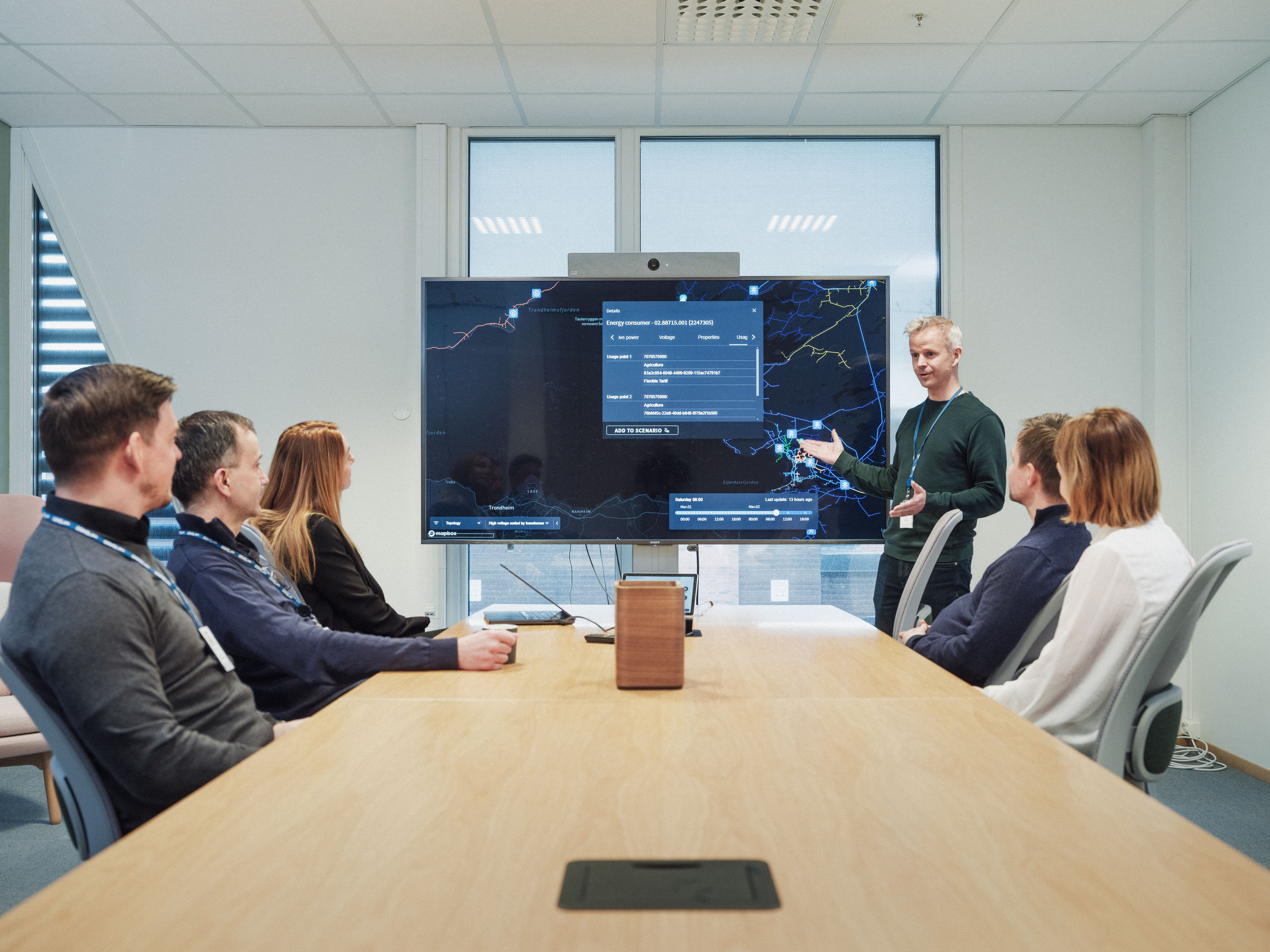 Bilde av flere personer som er samlet i et møterom 