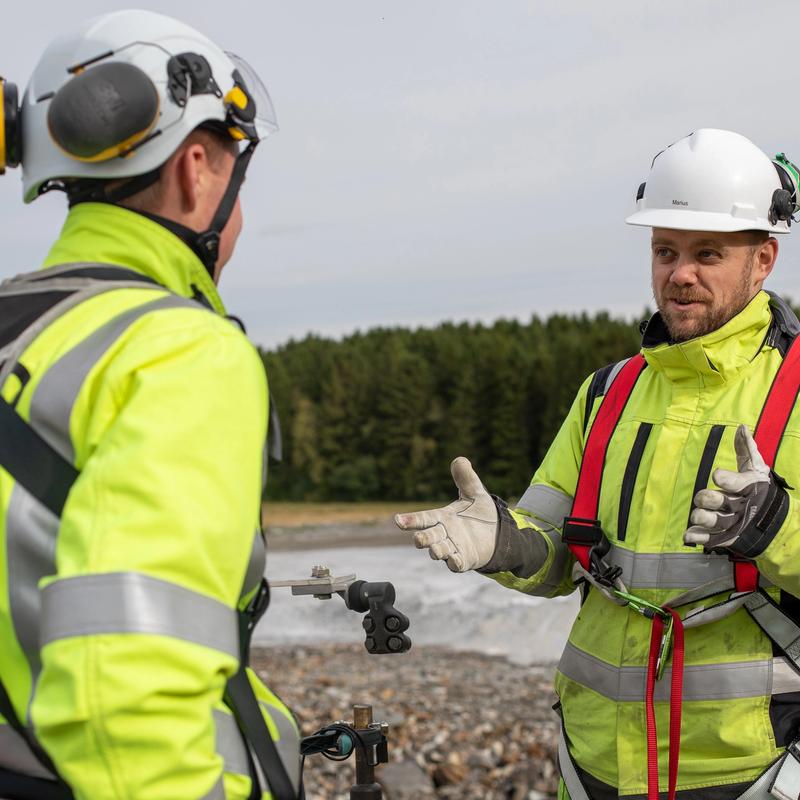 To montører som står å snakker sammen