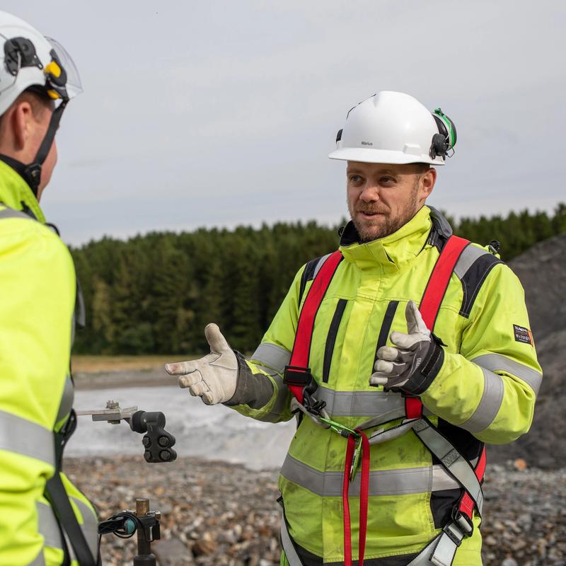 To montører som står å snakker sammen