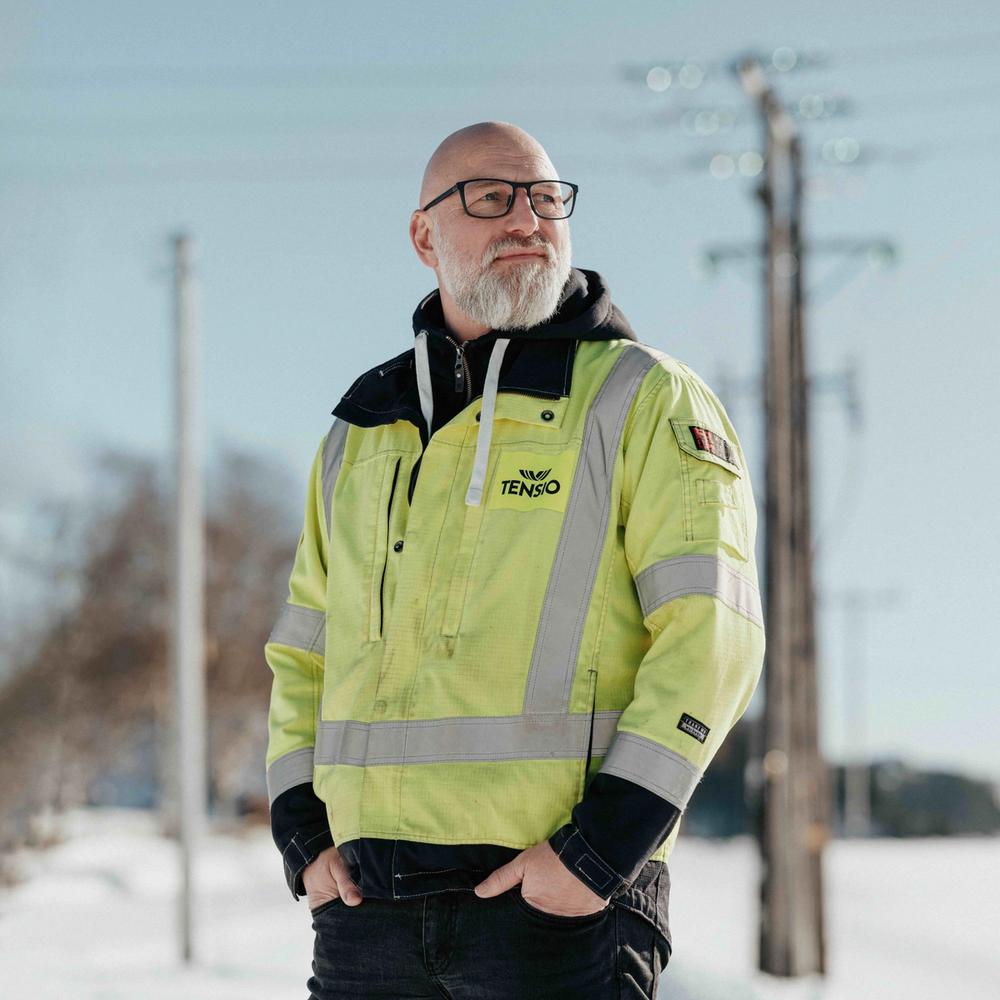 Tensio-ansatt i front av en strømmast