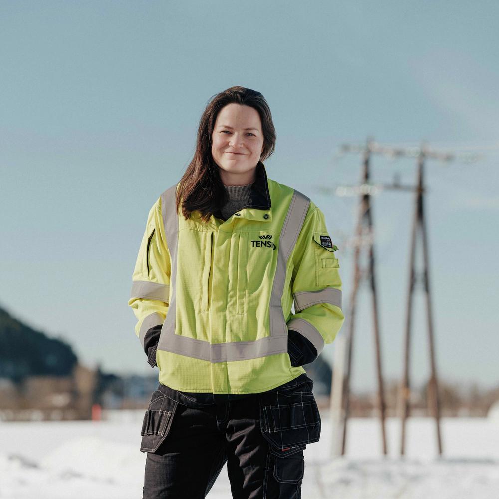 Tensio-ansatt i front av en strømmast