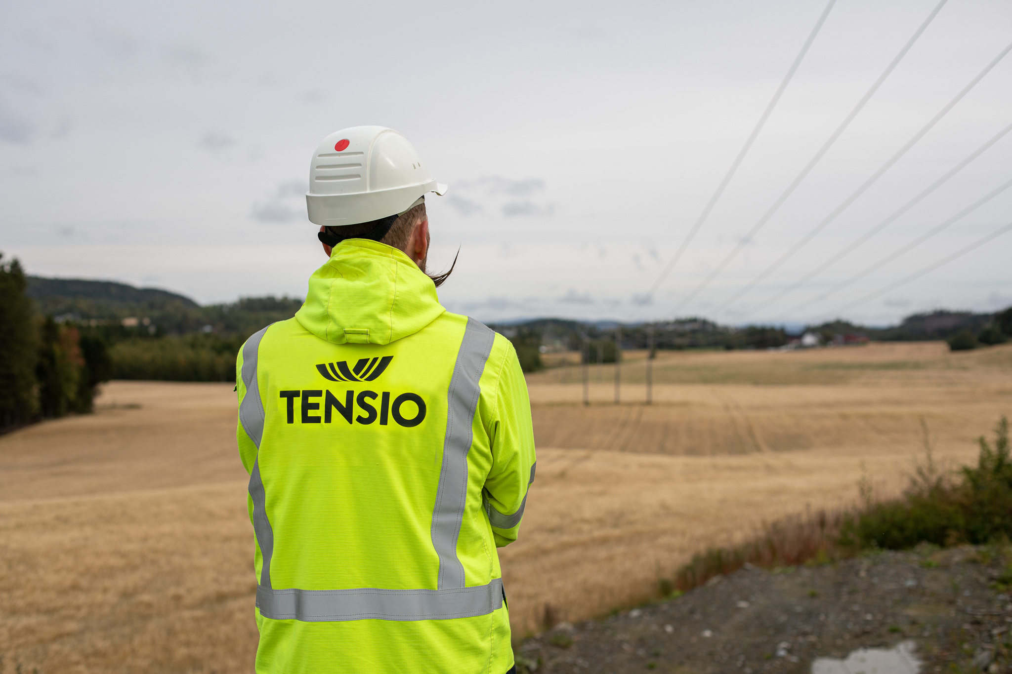 Montør som står å ser på en høyspenningskabel
