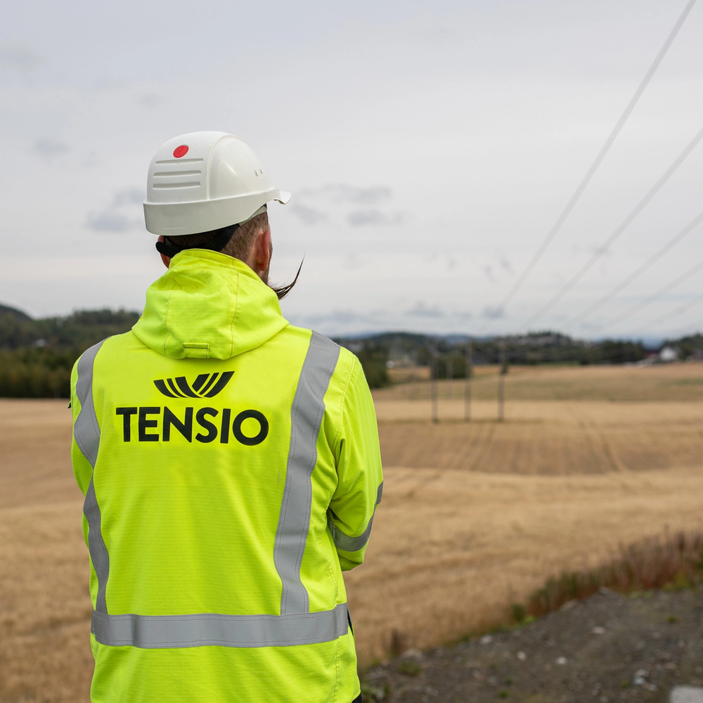 Montør som står å ser på en høyspenningskabel