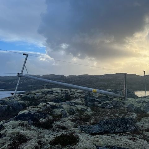 En høyspentmast som ligger på bakken