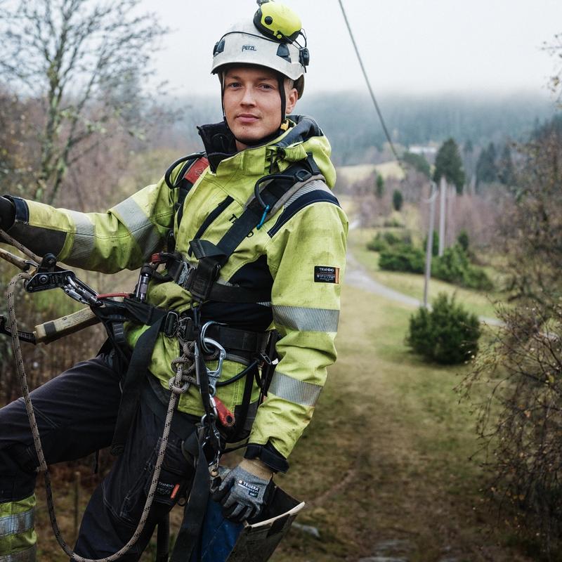 Tensio-montør som henger oppe i en strømstolpe