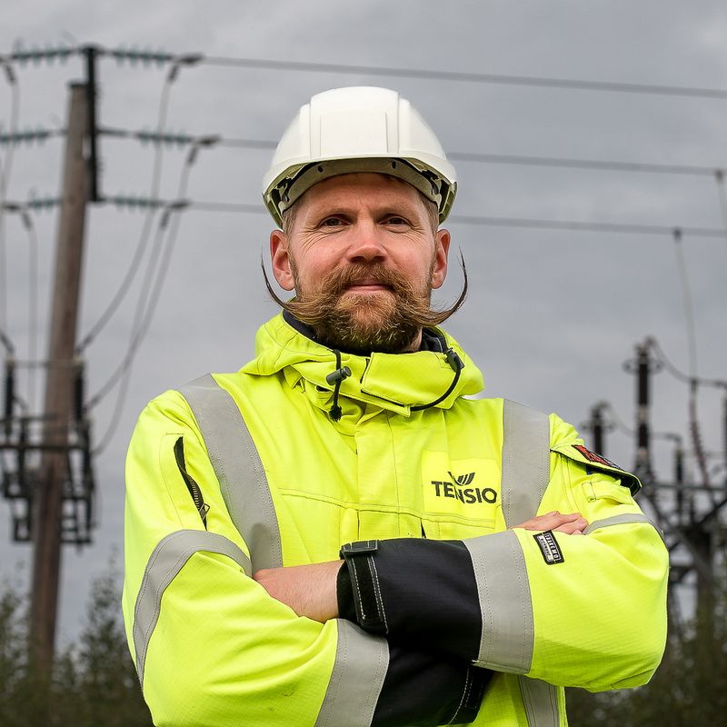 Tensio-ansatt i front av en strømmast