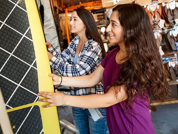 Two women browse stand-up paddleboards at a local outdoor recreation shop in Coos Bay, Oregon.