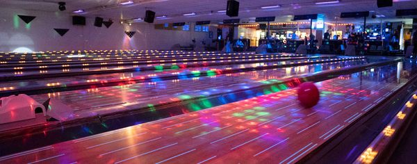 Bowling lanes lit with colorful disco lights during Cosmic Bowling at North Bend Lanes.