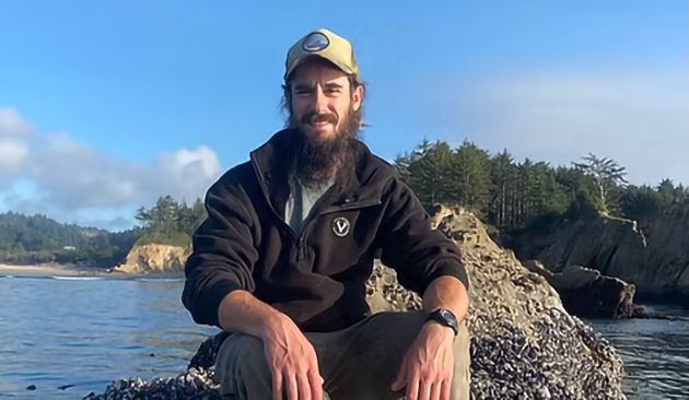 Guide Robbie McNulty sitting on a rock