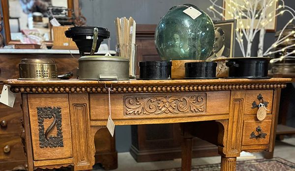 Large ornate vintage wooden desk with intricate carvings and a polished finish.