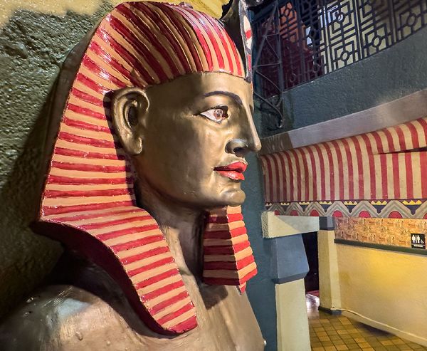 A large pharaoh bust with a striped nemes headdress stands in the lobby of the Egyptian Theater in Coos Bay, surrounded by hieroglyphic murals and Egyptian Revival décor.