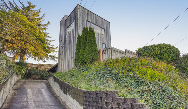 Two story structure on a hill with steep driveway and stunning views.