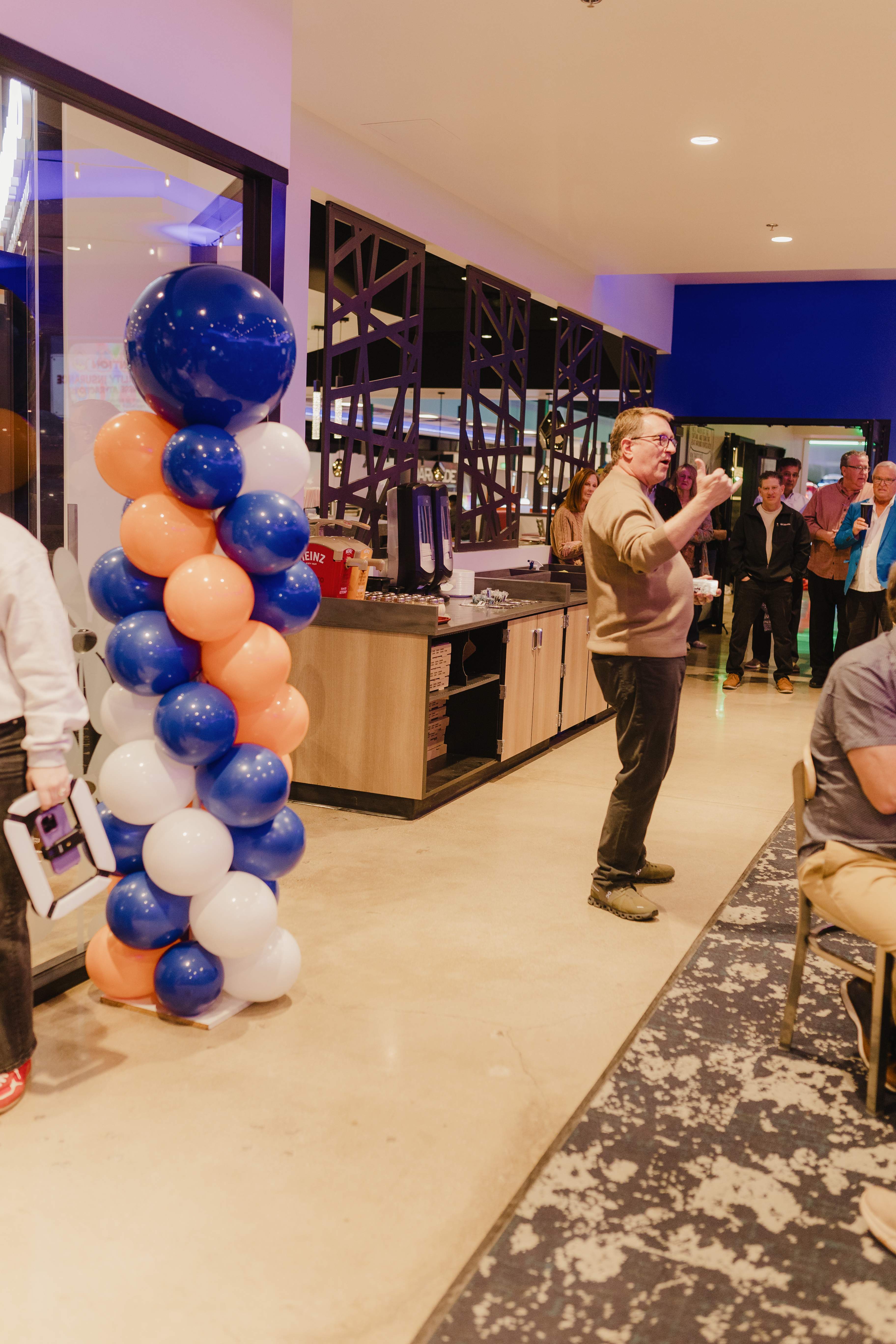A speaker addressing guests beside balloons at Bullwinkle's Upland