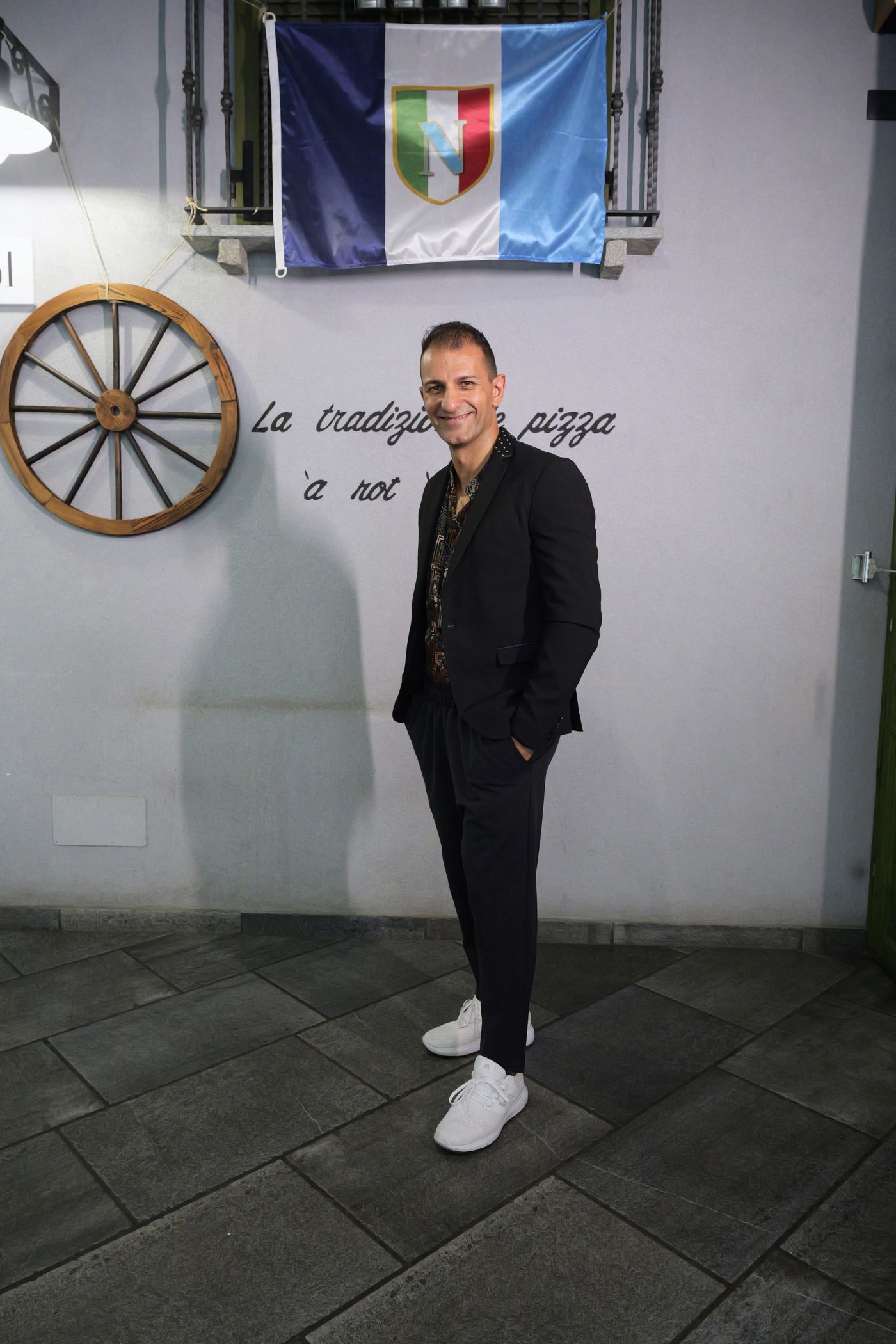 Gioacchino Cosentino sorride nel locale di Cos 'e Pazz, con la ruota di carro alle spalle