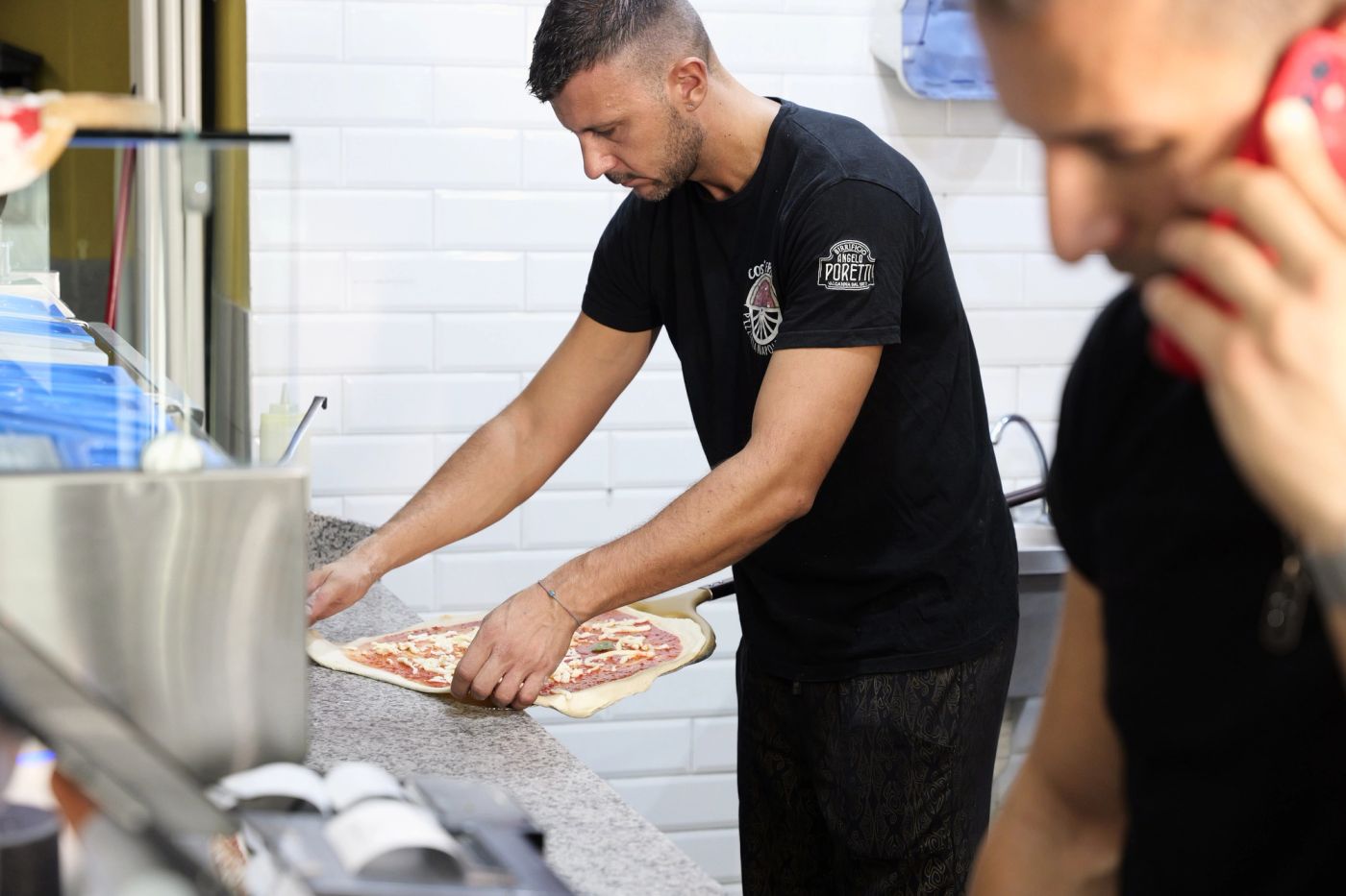 Luca Cosentino al forno di Cos 'e Pazz mentre inforna la pizza con la pala