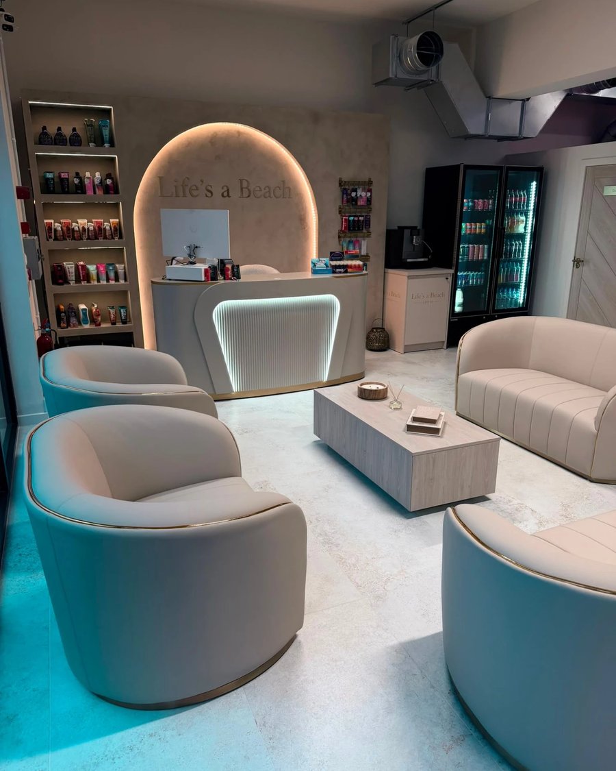Life’s a Beach salon interior — cream lounge seating and backlit reception arch