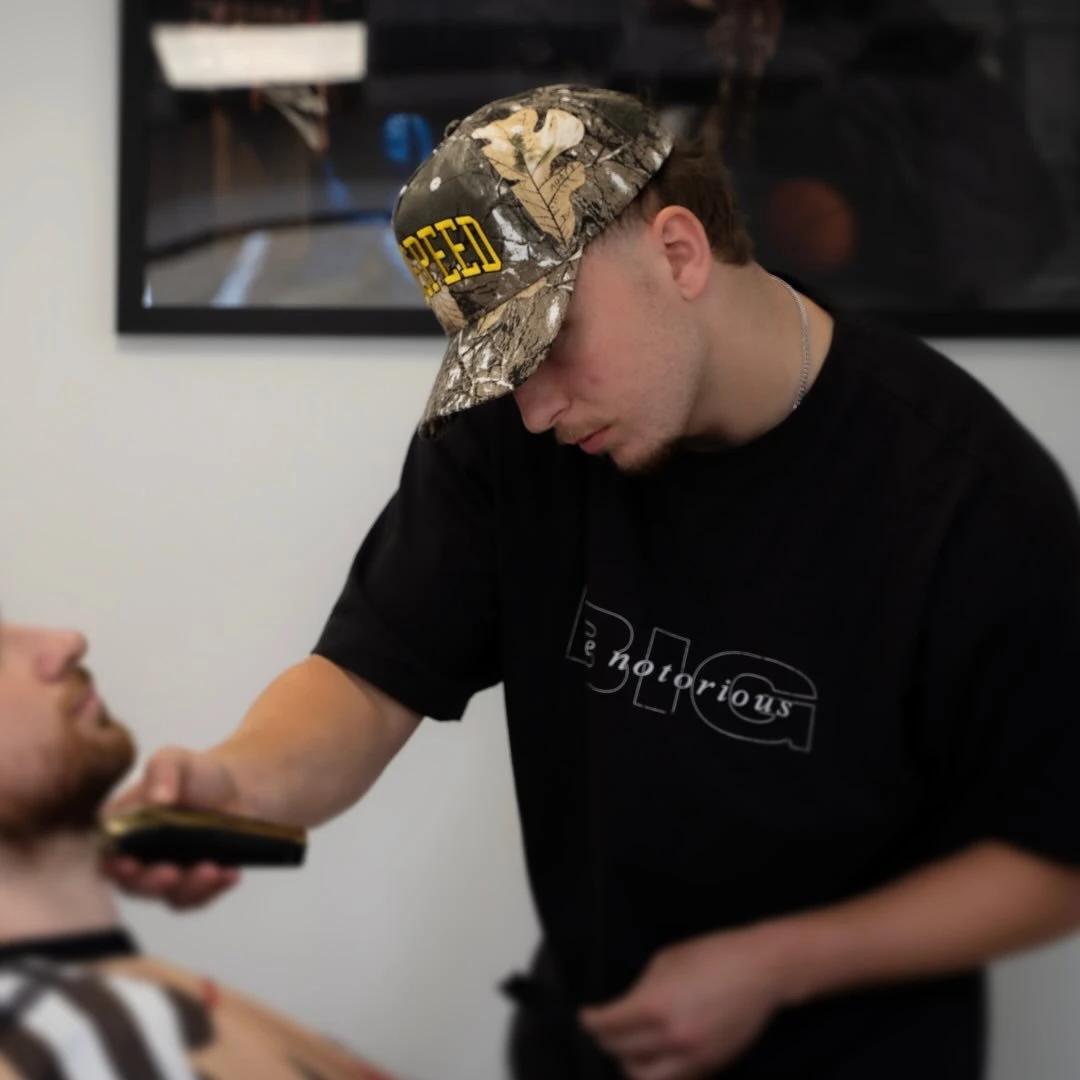 Scott Cowie trimming a client’s beard at Cowiecutz