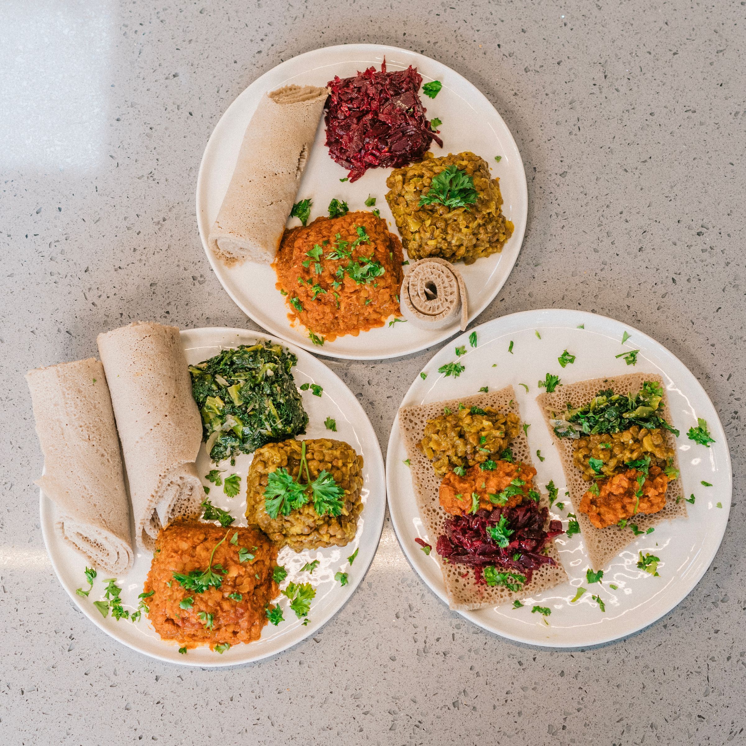 Injera served with colourful stews, seen from above
