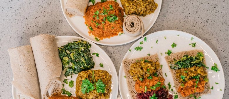 Injera served with colourful stews, seen from above