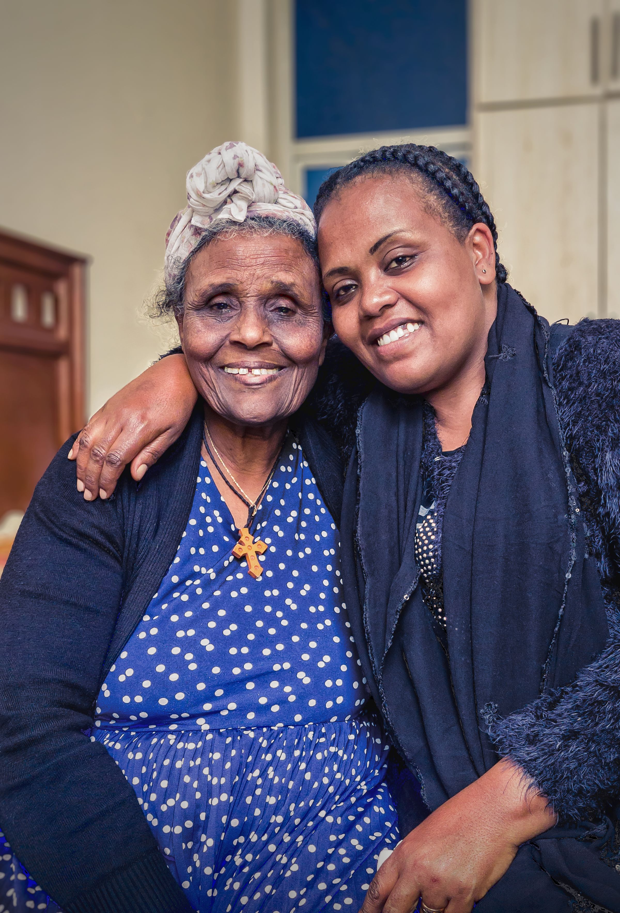 An elderly woman and her granddaughter sharing a warm moment at home in Addis Ababa