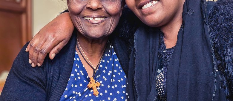 An elderly woman and her granddaughter sharing a warm moment at home in Addis Ababa