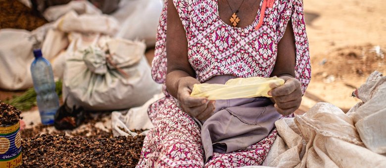 A woman sorting grain at a local market in Ethiopia