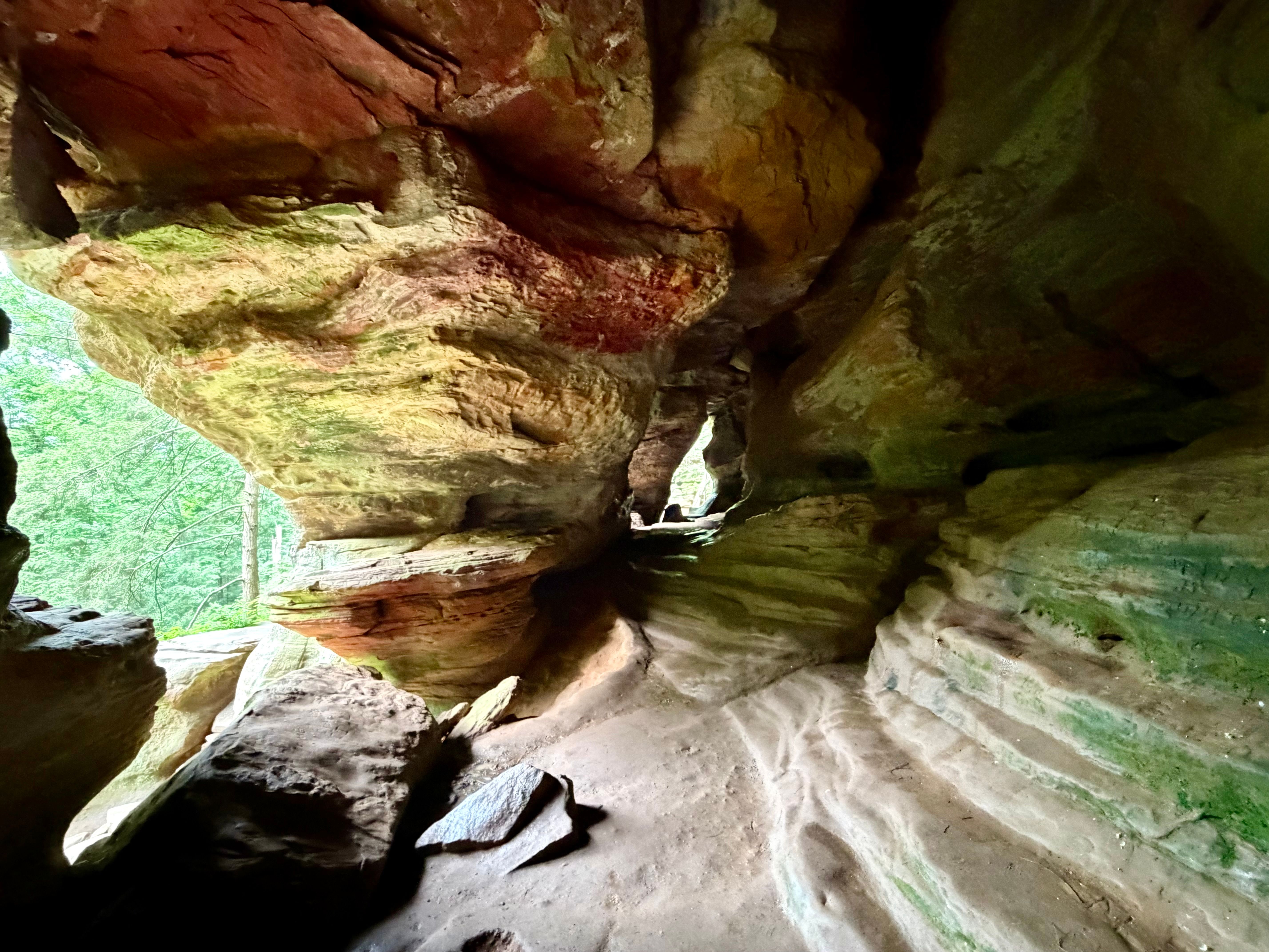 Interior of Rock House showing layered sandstone walls, natural windows, and a winding cave passage.