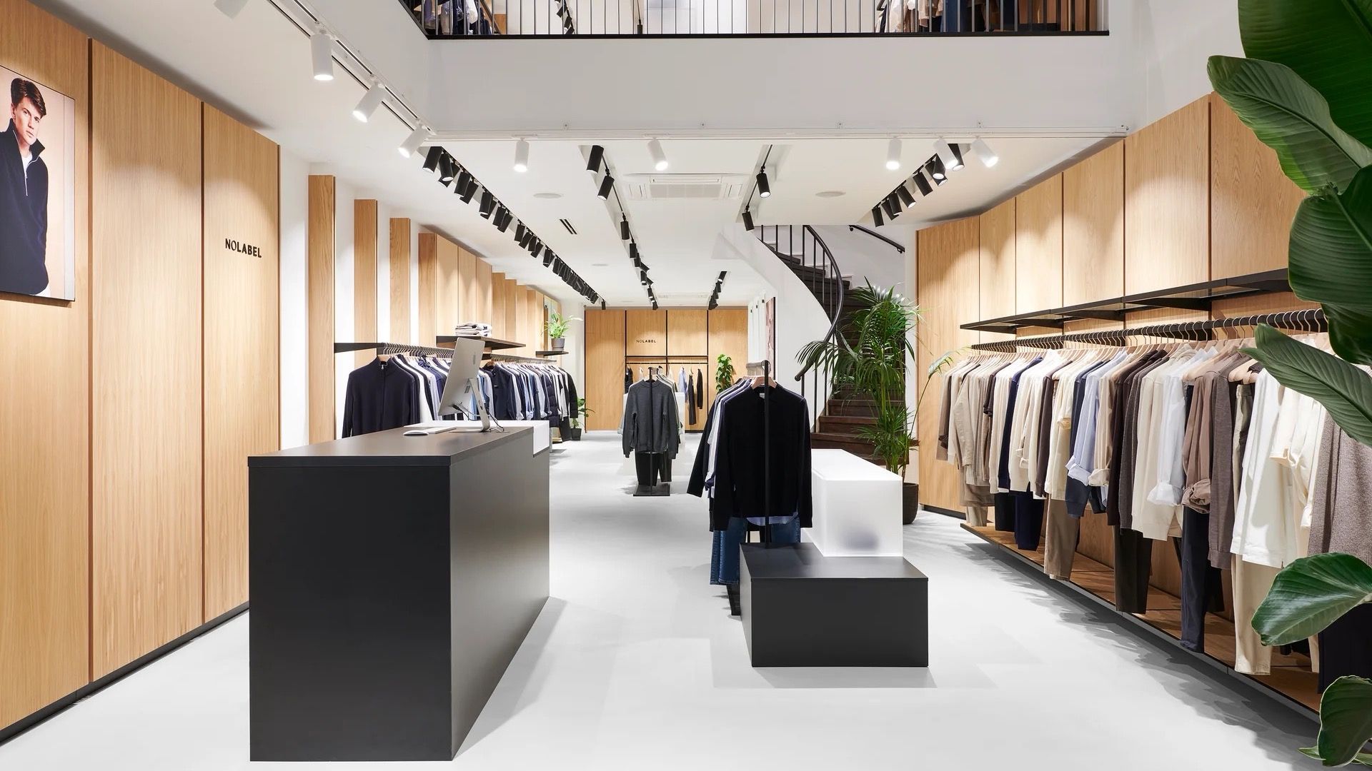 The NoLabel store interior, with oak fixtures and rails of menswear essentials