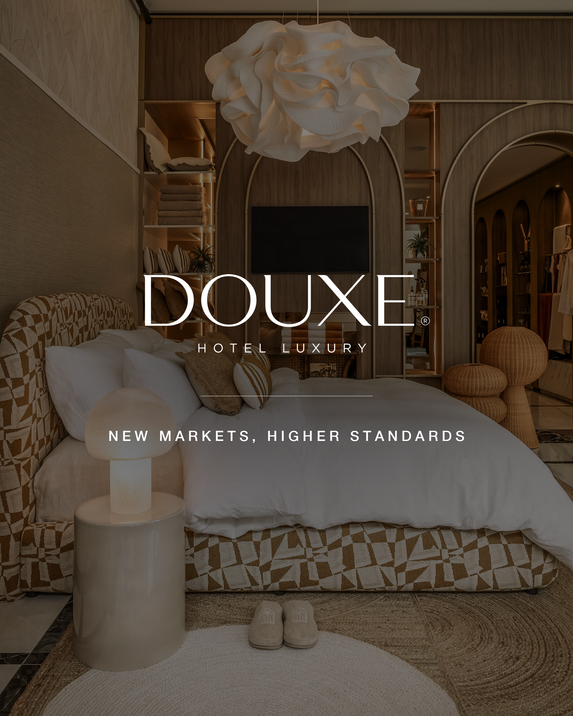 DOUXE Hotel Luxury: the DOUXE flagship store with a dressed signature bed, with the DOUXE Hotel Luxury wordmark