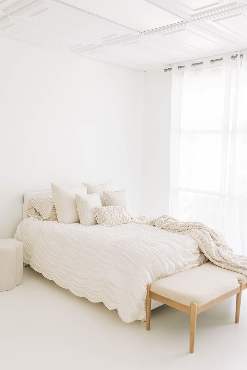 Studio A: soft window light across the styled bed and white floors