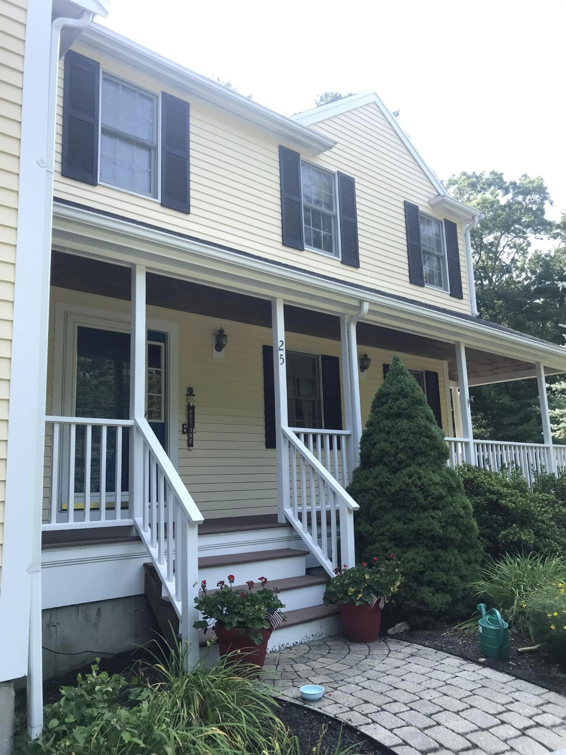 A yellow colonial home with white porch and trim painted by Brookstone Painting and Carpentry in Plymouth County and Cape Cod