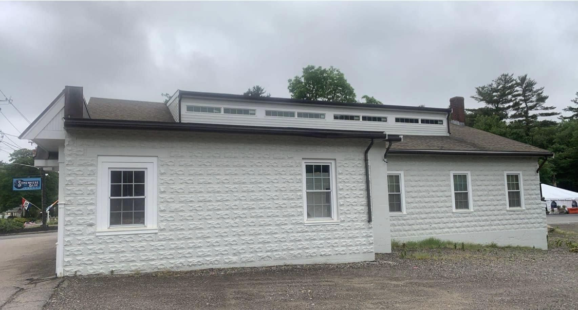 A long white building with clean, bright repainted siding by Brookstone Painting and Carpentry in Plymouth County