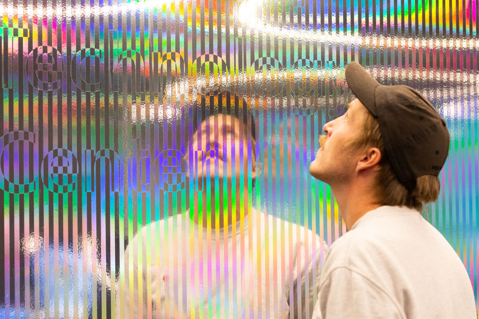 Mann speiler seg selv i installasjonsvegg for Microsoft. Foto.