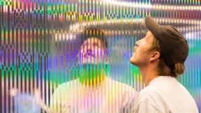 Mann speiler seg selv i installasjonsvegg for Microsoft. Foto.