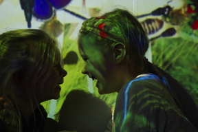 Barn som ler foran interaktiv skjerm. Foto. Kreditering: Nasjonalmuseet