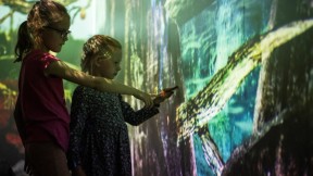 Barn som peker på interaktiv skjerm. Foto. Kreditering: Nasjonalmuseet