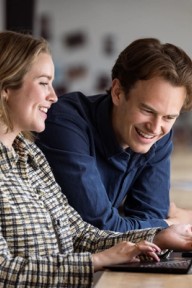 To forretningsrådgivere i en samtale foran en laptop. Foto.