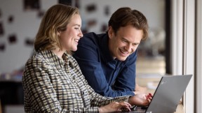 To forretningsrådgivere i en samtale foran en laptop. Foto.