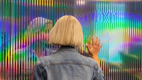 Dame speiler seg selv i installasjonsvegg for Microsoft. Foto.