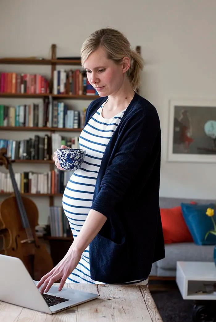 Gravid kvinne foran dataskjerm. Foto.