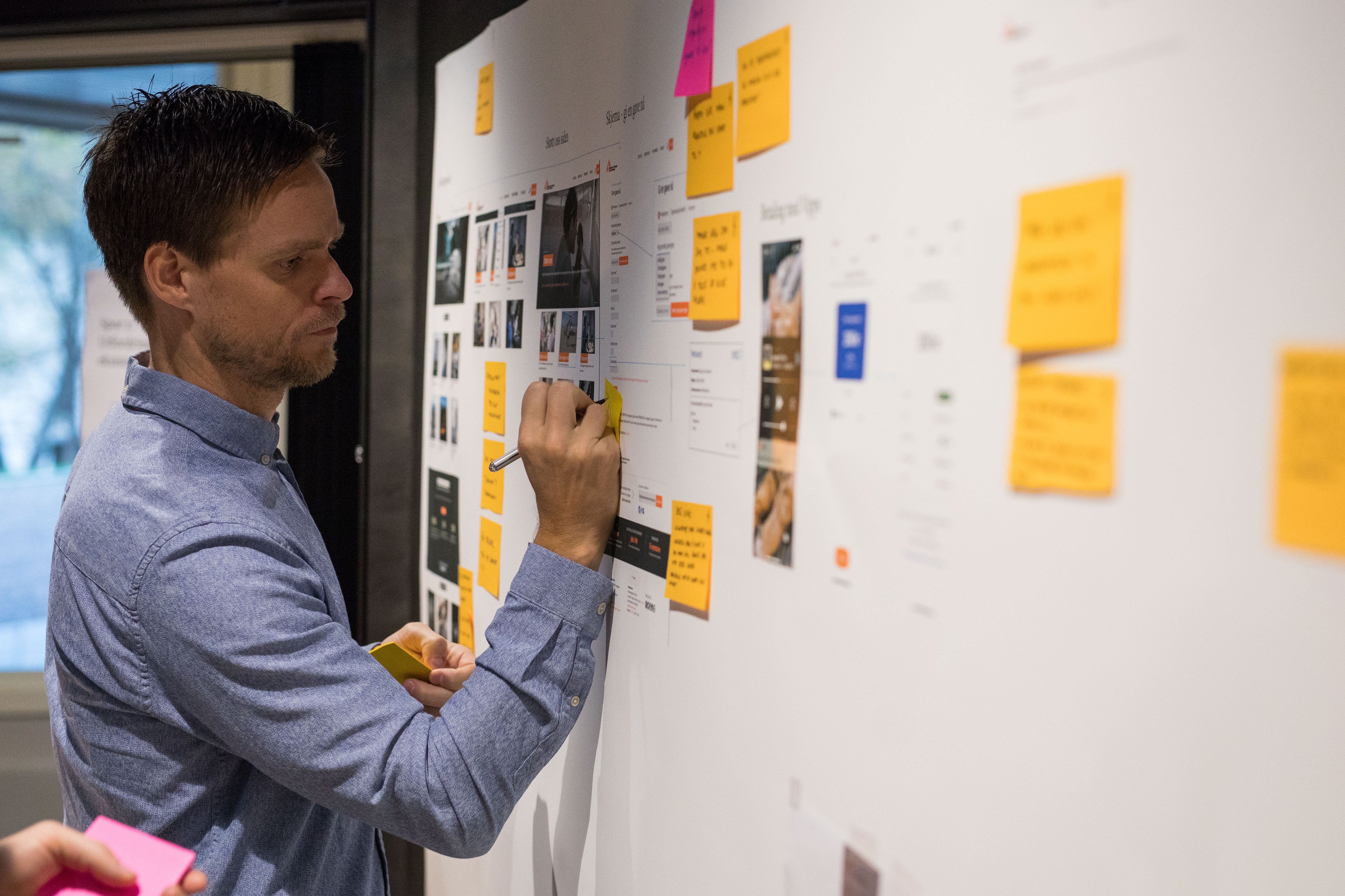 Designer skriver på en vegg. Foto.