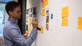 Designer skriver på en vegg. Foto.