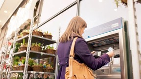 Dame som tar ut penger i en minibank. Foto. Kreditering: DanskeBank