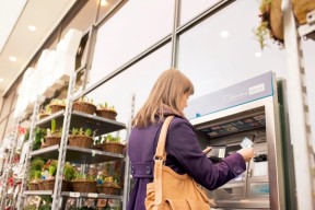 Dame som tar ut penger i en minibank. Foto. Kreditering: DanskeBank