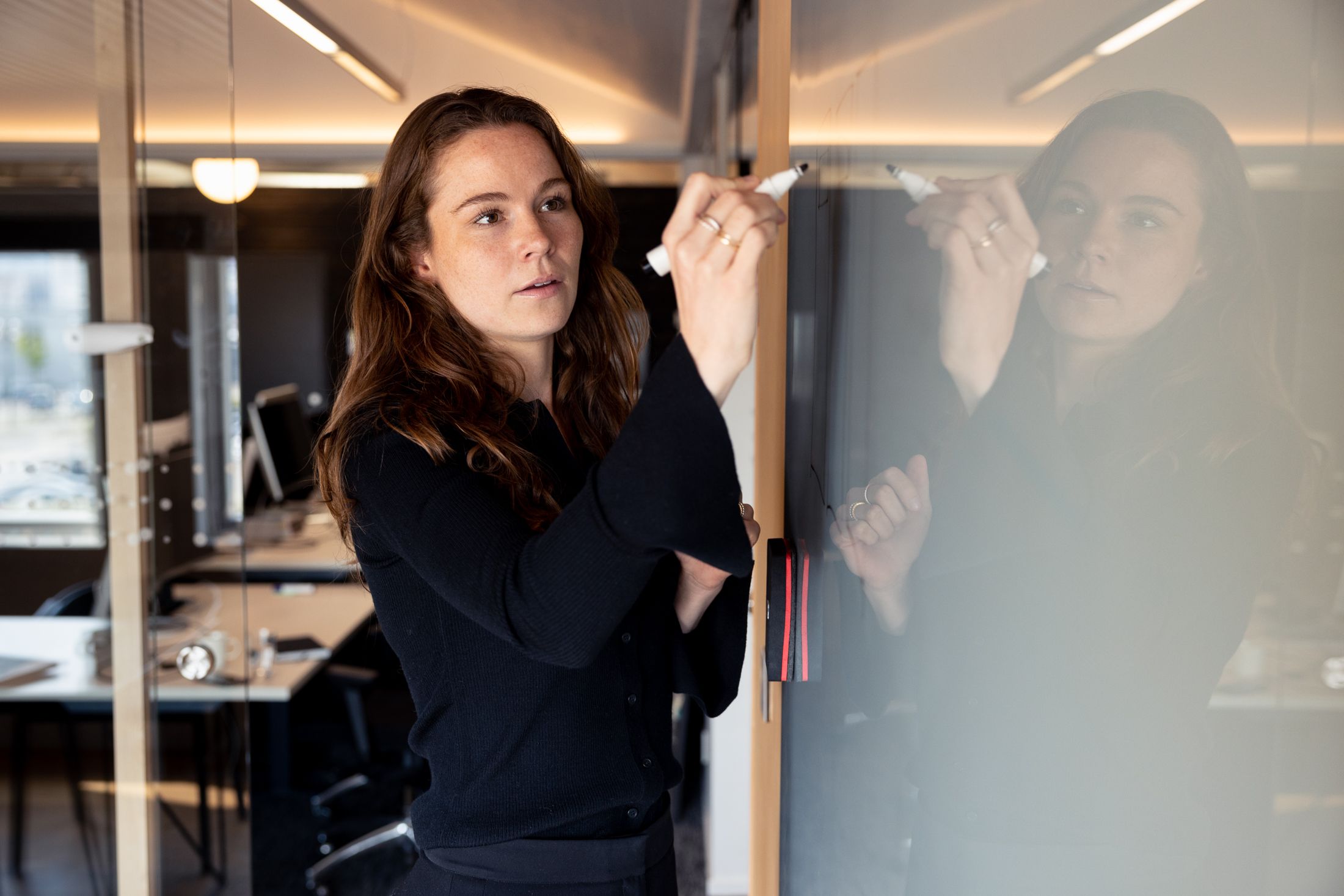 Forretningsrådgiver skriver på tavle. Foto.