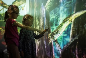 Barn som peker på interaktiv skjerm. Foto. Kreditering: Nasjonalmuseet